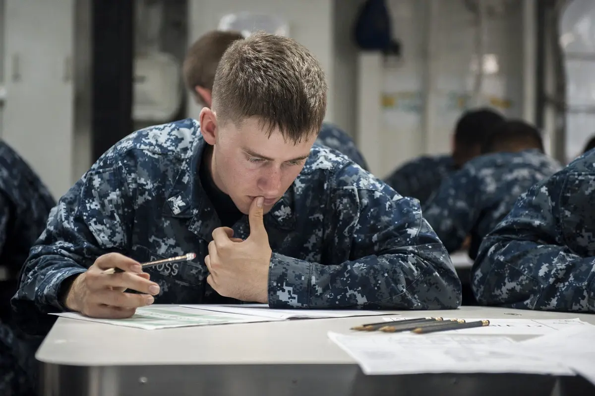 Man sitting at desk wearing navy uniform